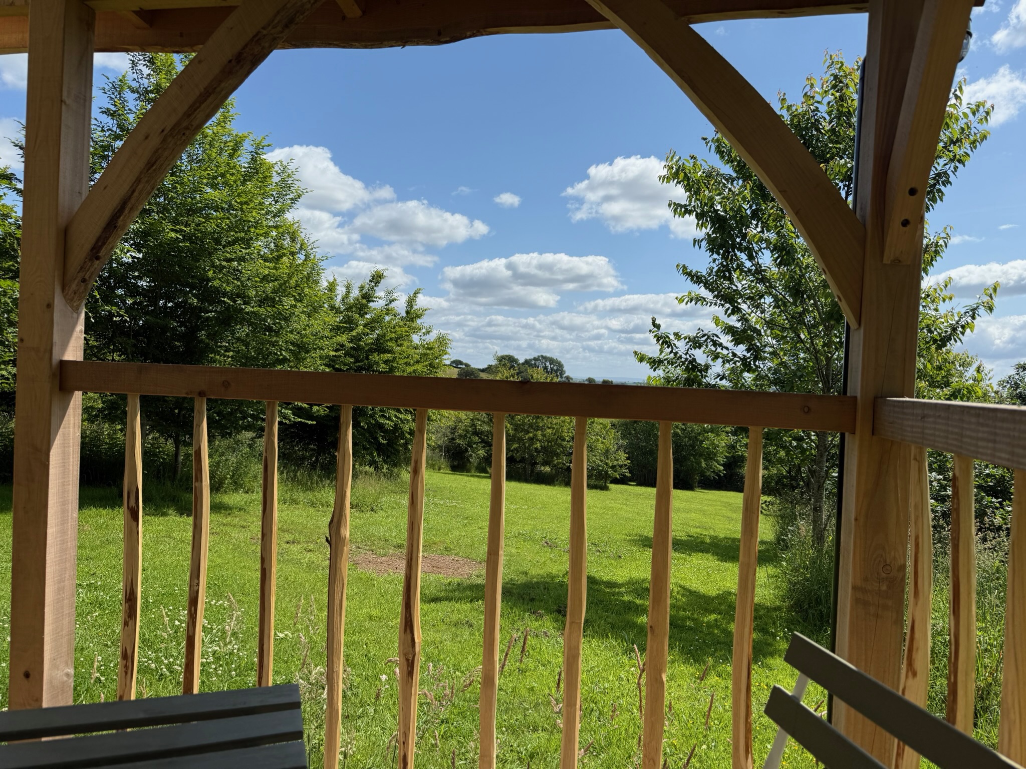 view of the countryside through the wooden fence of a shepherd's hut