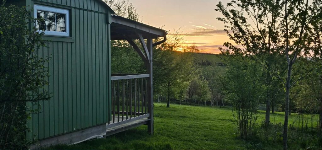sunset looking out across the fields with a shepherd's hut in the foreground